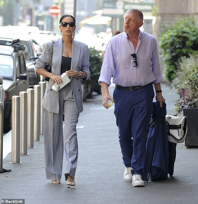 Boris carried a navy blazer and pulled his belongings behind him in a black suitcase and white duffel bag
