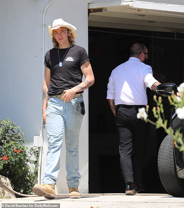 The teenager was also spotted walking down the driveway as a car, seemingly belonging to the coroner, slowly backed into it