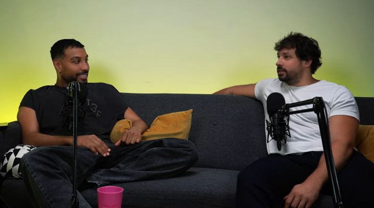 Two men sitting on a couch during a podcast interview.