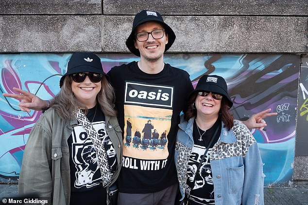 The streets of Cardiff are 'electric' ahead Oasis's opening night with Wonderwall blasting from work vans while superfans are queuing up to purchase bucket hats and T-shirts [pictured: Jarreth, Holly and Sarah from Bridgend, South Wales]
