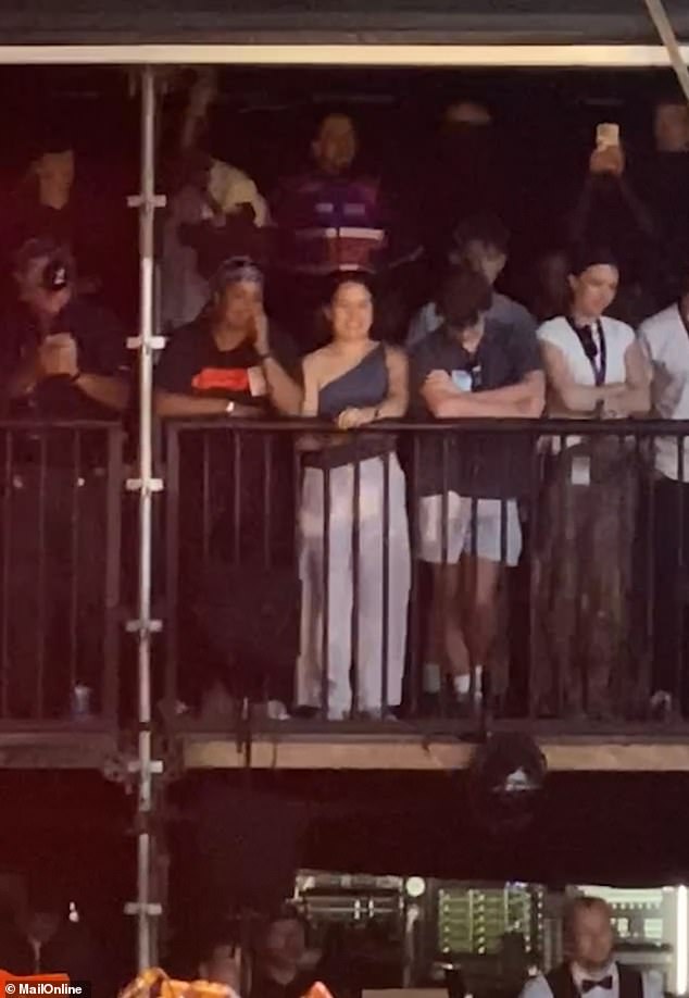 The sportsman [pictured back row, centre] attempted to keep a low profile as the gig as he stood back in the shadows behind Raye's supporters at the side of the stage