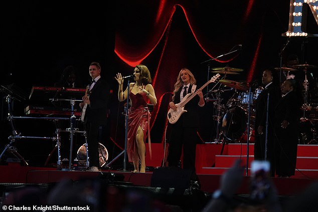 Raye looked sensational in a figure-hugging red leather gown, with Lewis barely able to take his eyes off her as he enjoyed the show