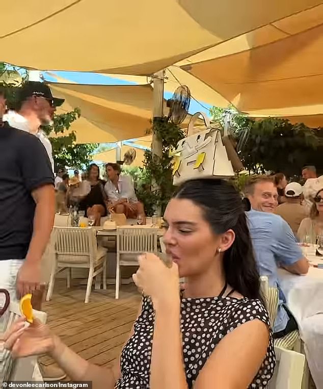 The model, 29, hid a grimace as her friends recorded her taking the shot of hard liquor as they screamed in excitement, as seen in model Devon Lee Carlson's Instagram post on Saturday