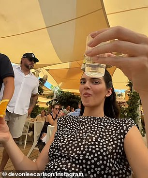 While vacationing with friends in Saint-Tropez located in the south of France, the supermodel was seen taking a shot while balancing a $60,000 handbag on her head