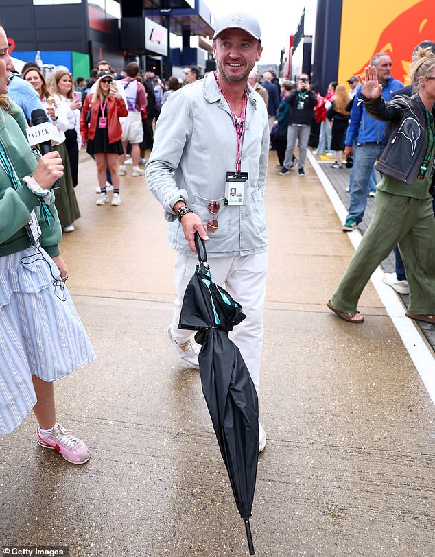 Harry Potter star Tom Felton had his umbrella at the ready on a miserable day in Northamptonshire