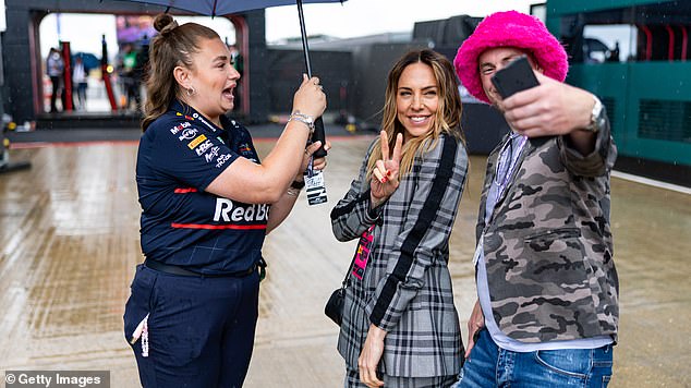 The singer posed for selfies while a Silverstone staff-member protected her from the rain by holding an umbrella above her head