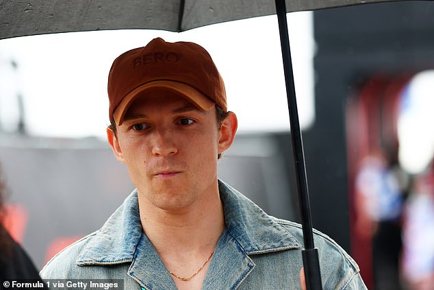 Actor Tom Holland sheltered beneath an obligatory umbrella as the rain fell across Silverstone on Sunday