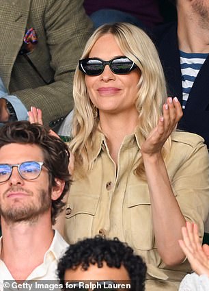 Shielding her eyes behind chic shades she cheered on from her seat