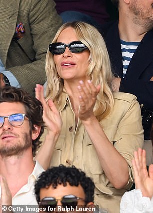 Shielding her eyes behind chic shades she cheered on from her seat