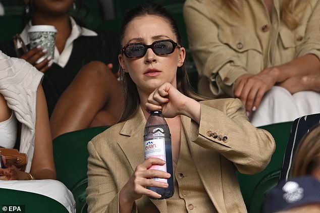 Shielding her eyes behind shades she kept cool with mineral water