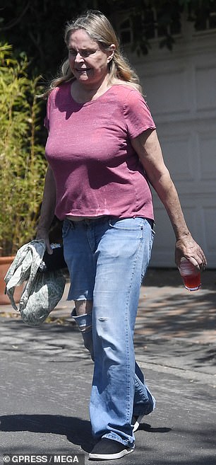 She wore relaxed jeans that were ripped at the knee and a magenta T-shirt that she wore without a bra