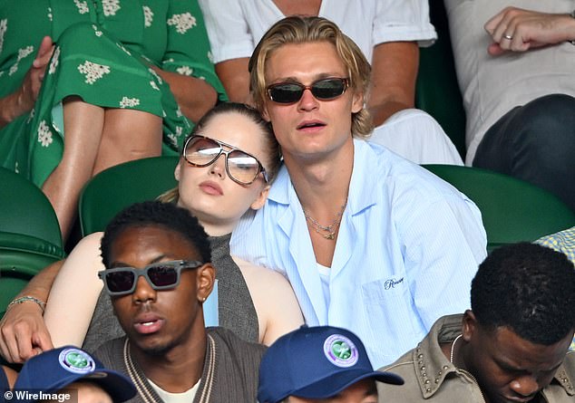 She cuddled up to the hunk while Novak Djokovic took on Australia's Alex de Minaur on Monday afternoon