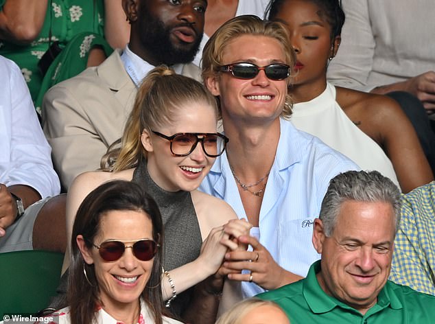 Despite the action on the court the lovebirds only seemed to have eyes for each other as they giggled and chatted intently while holding hands