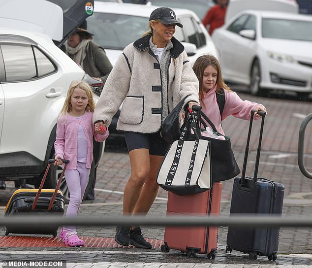 Carrie appeared to have on minimal makeup and towed along a pile of luggage including a carry-on case, a tote and a handbag