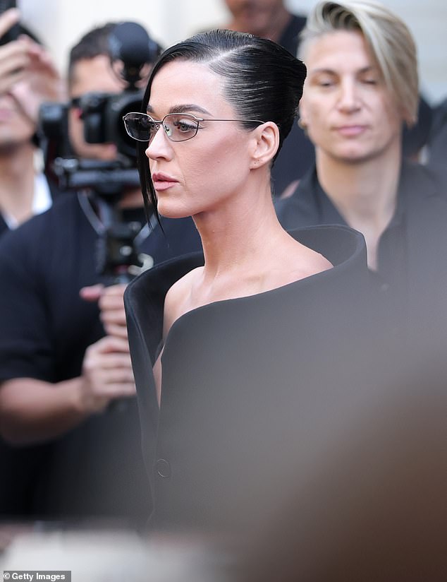Perry's hair was combed back and styled with a side-parting, while clear lens spectacles served as her only notable accessory