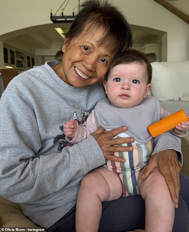 Her album included a touching photo of Kim in the middle of her recovering cradling Olivia and John's daughter Méi, whom they welcomed via surrogate last September