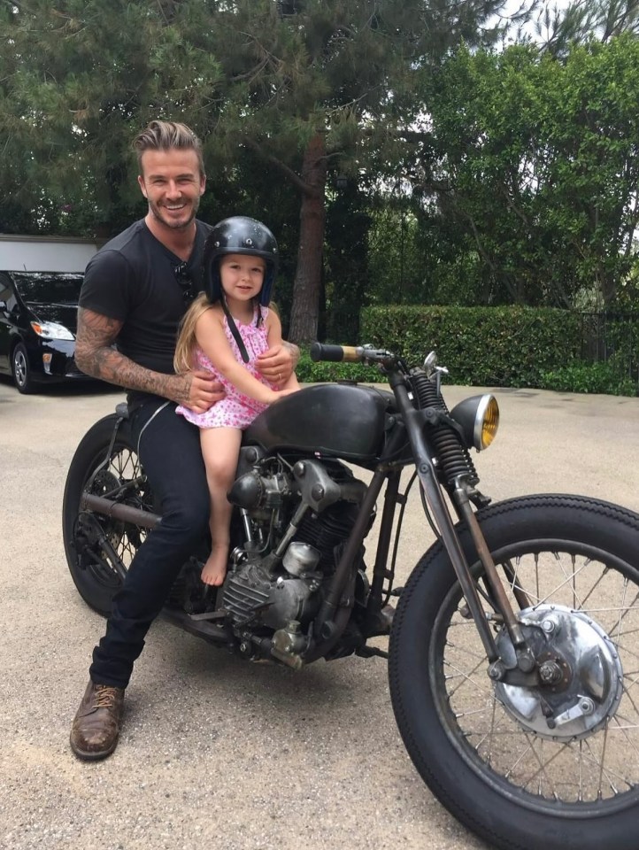 David Beckham and his daughter Harper Seven sitting on a motorcycle.
