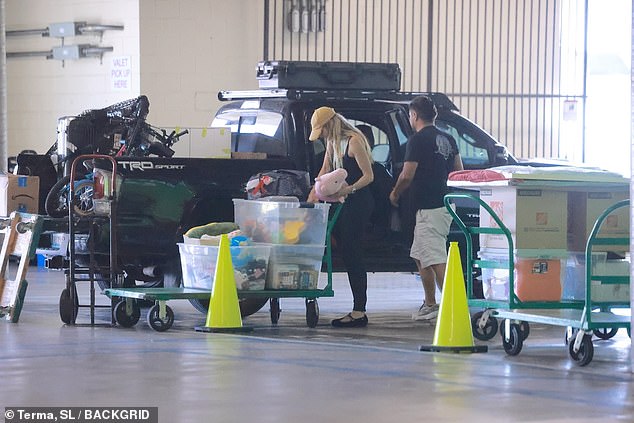 The blonde beauty wasn't afraid to get her hands dirty as she helped a mystery man unload his truck, which contained a various array of household items
