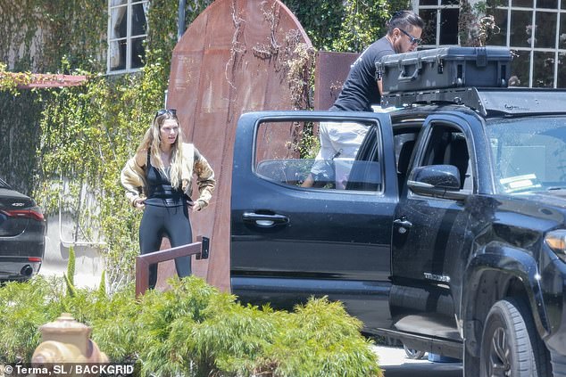 At one point, she opted for a brown camo jacket and tucked her tresses behind a pair of designer glasses