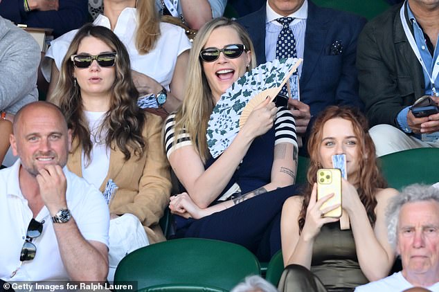 Cara looked in great spirits as she beamed beside her mystery date as she fanned herself in the hot weather