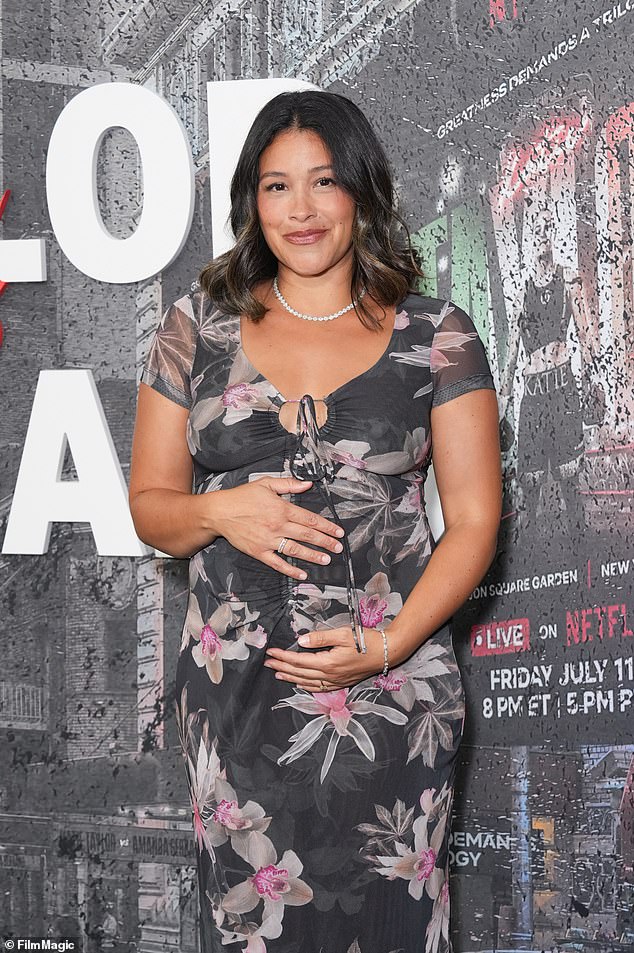 She showed off her baby bump in a striking black floral dress