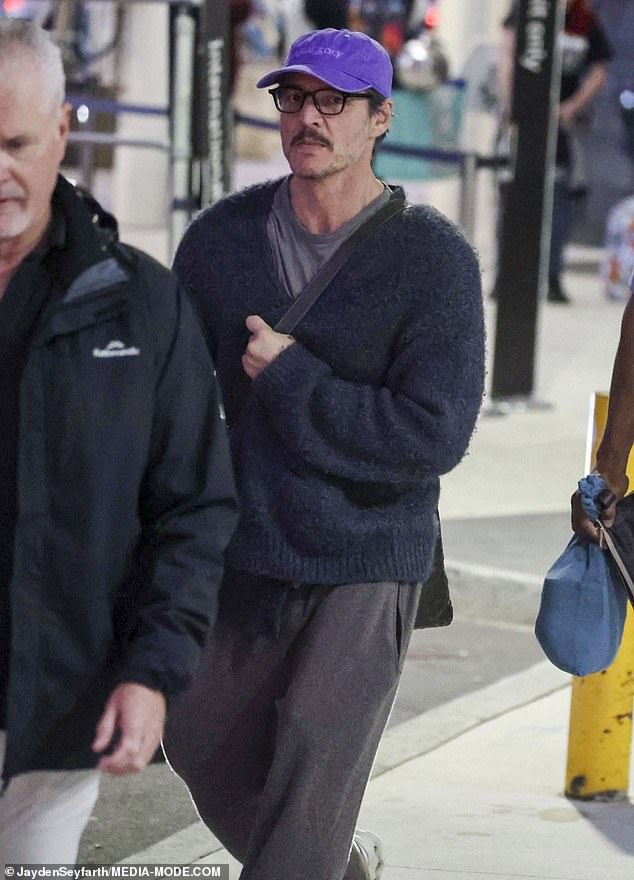 Pedro, 50, best known for his roles in The Last of Us and The Mandalorian, cut a low-key figure in an oversized charcoal knit, matching relaxed pants and a deep purple baseball cap