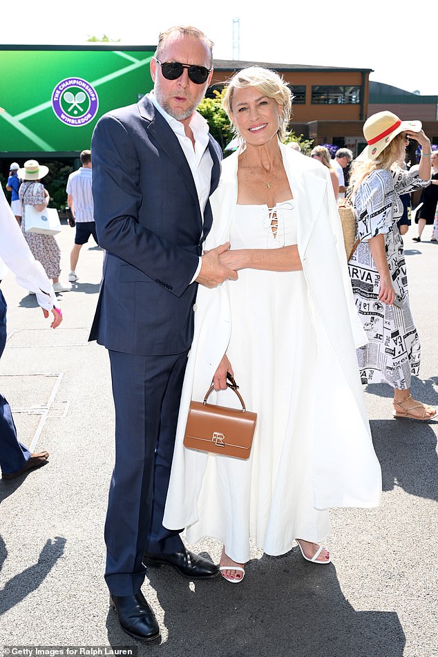 Robin Wright commanded attention in an flowing white dress with a lace-up front and matching coat, as she cosied up to a dashing Henri Smith