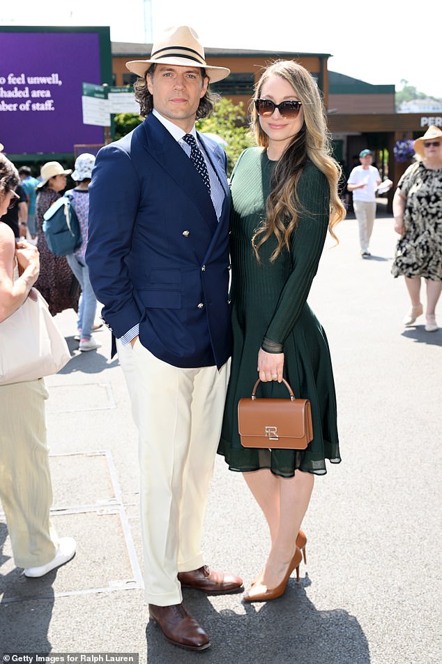 Henry put on a very dapper display in a navy blue double breasted blazer and cream trousers, with a polka dot tie and a straw fedora as he posed with his girlfriend Natalie Viscuso