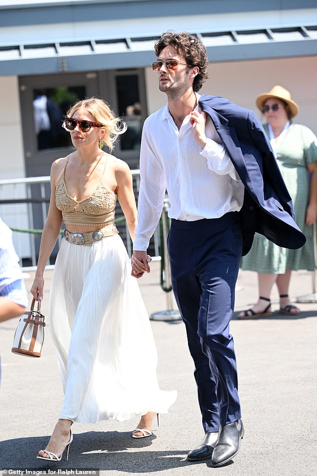 The actress arrived hand-in-hand with her boyfriend Oli Green, 28, who was quick to whip off his suit jacket and sling it over his shoulder amid the sweltering temperatures