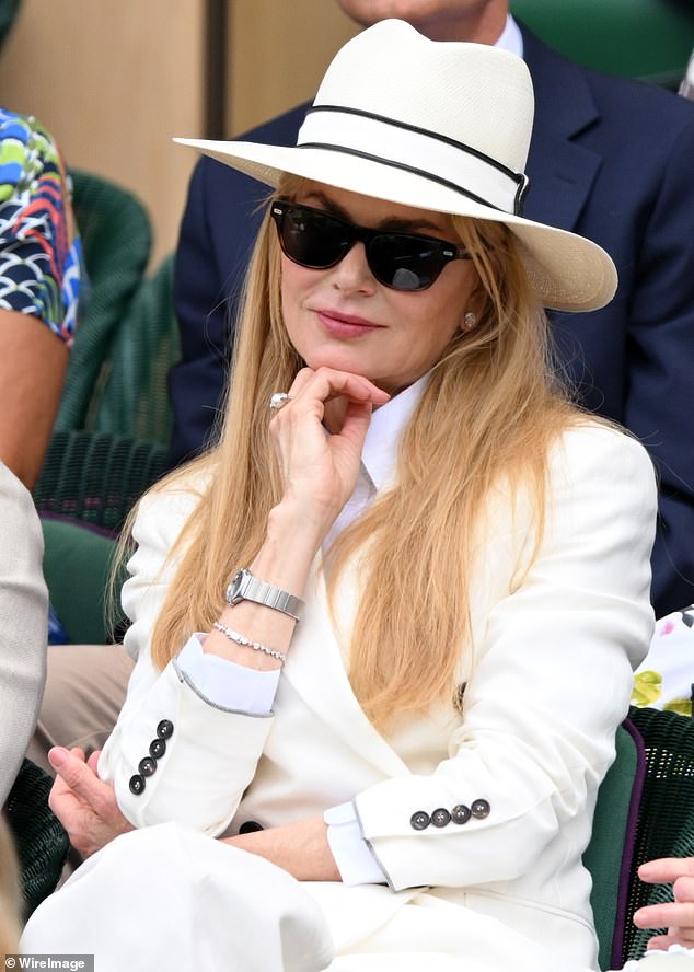 The film star was suited and booted in a white double-breasted blazer and matching trousers, which featured button detail