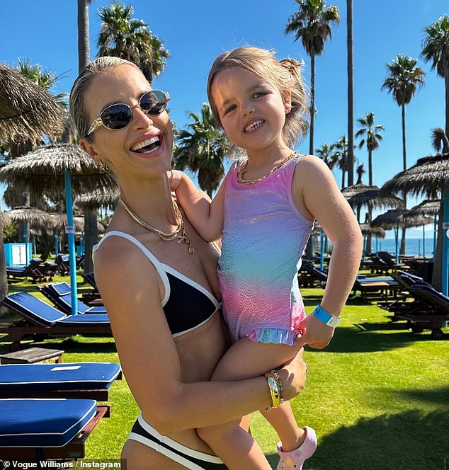 In one snap Vogue can be seen wearing a black and white two-piece as she cradled Otto, before also picking up her daughter Gigi.