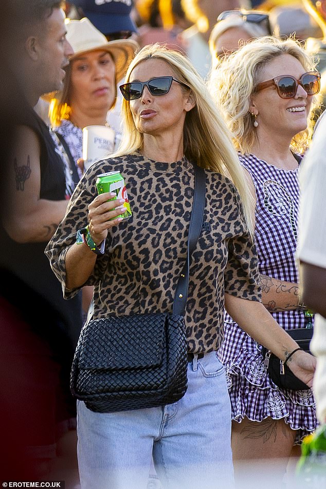 She toted her essentials in a black crossbody handbag and clutched a drink in one hand