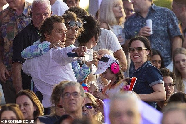 Matthew cut a suave figure in a white shirt as he wrapped his arm around Ronnie, who put on a vibrant display in a bright blue patterned shirt