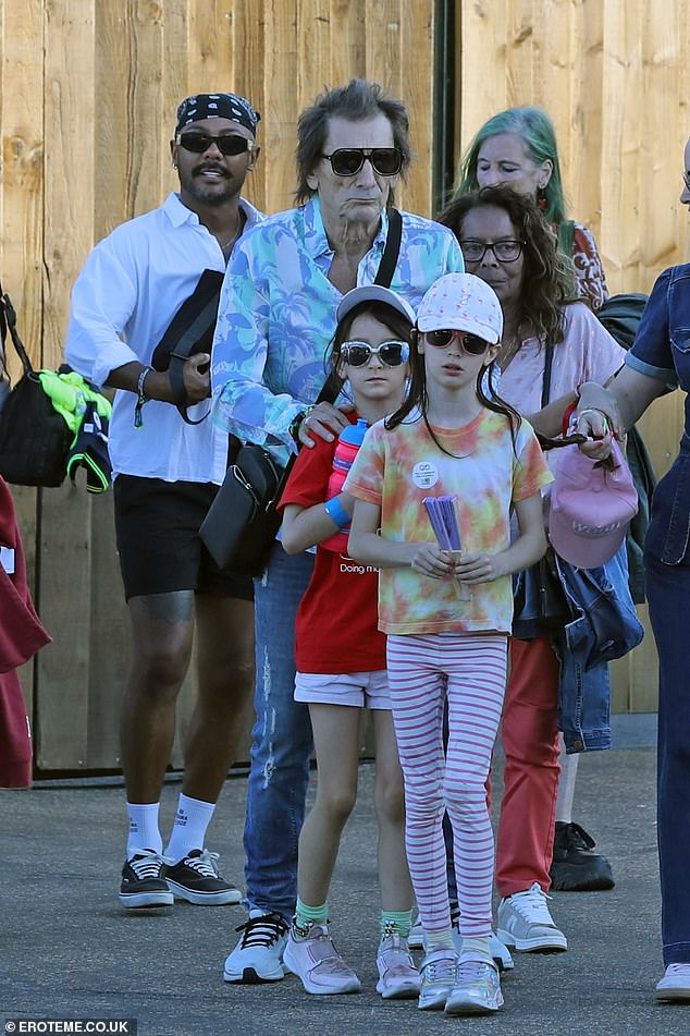 Ronnie sweetly placed his hands on his daughters' shoulders as he guided them through the busy crowds