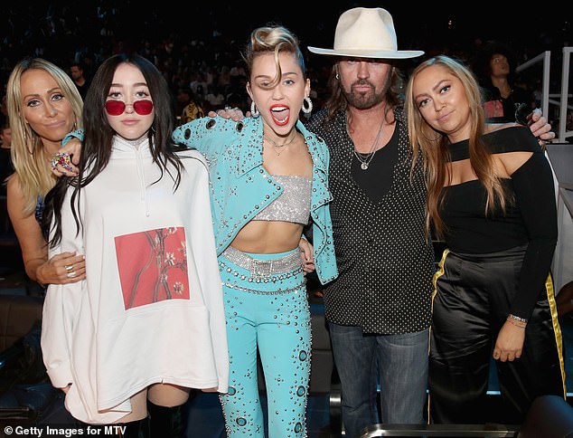 Noah Cyrus (second from left) is pictured in 2017 with her mother Tish (left), her sisters Miley (center) and Brandi (right) and her father Billy Ray (second from right)
