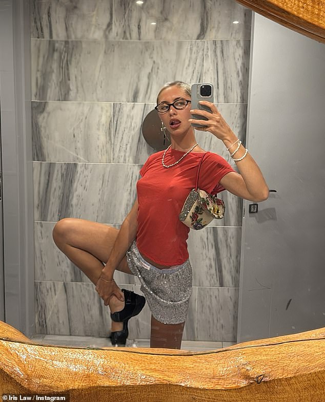 In another snap, Iris could be seen going braless as she posed for a mirror selfie in a red T-shirt with silver sequin shorts and chunky black sandals