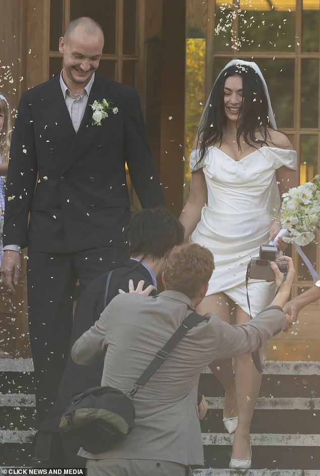 Guests threw confetti as the pair emerged after signing the marriage register