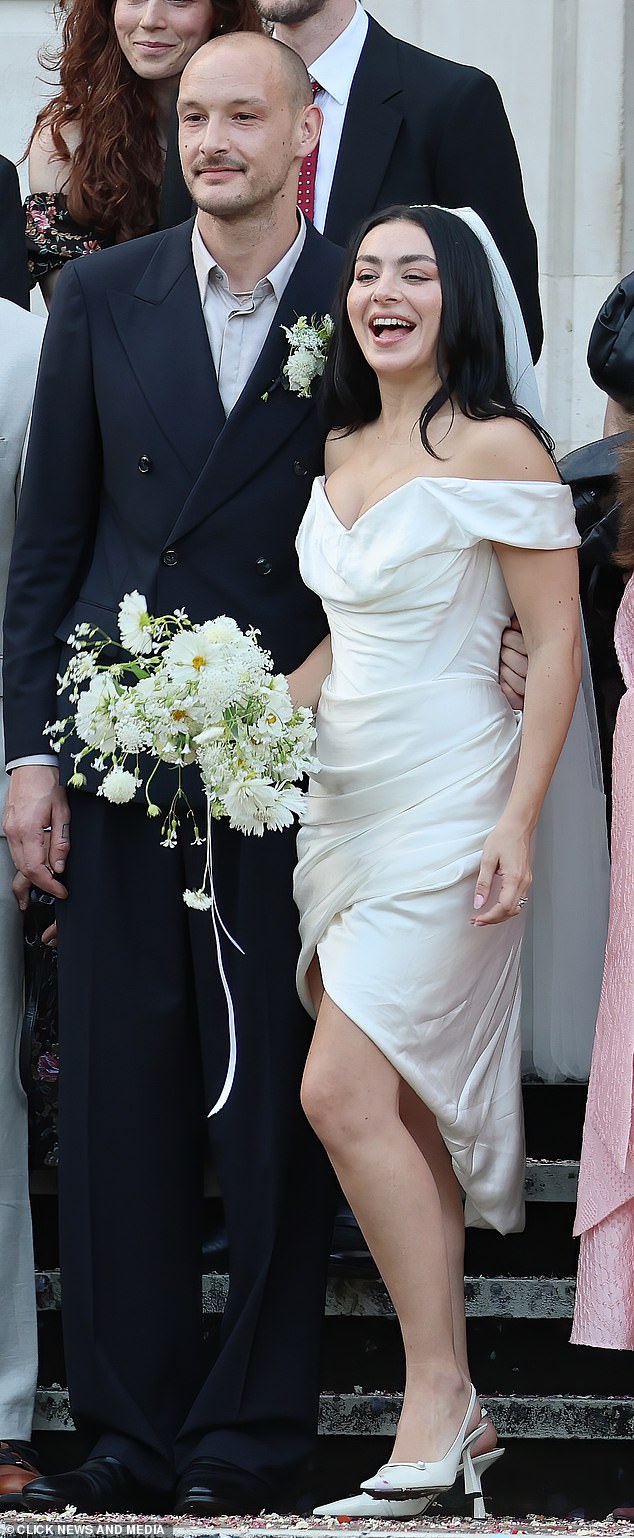 Slipping her feet into heels, she wore her long raven tresses loose and carried a bouquet of white flowers