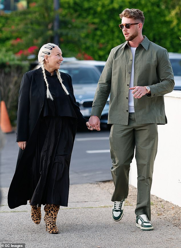 Sia, whose last name is Furler, opted for a moody ensemble consisting of a baggy black high-necked tiered maxi dress