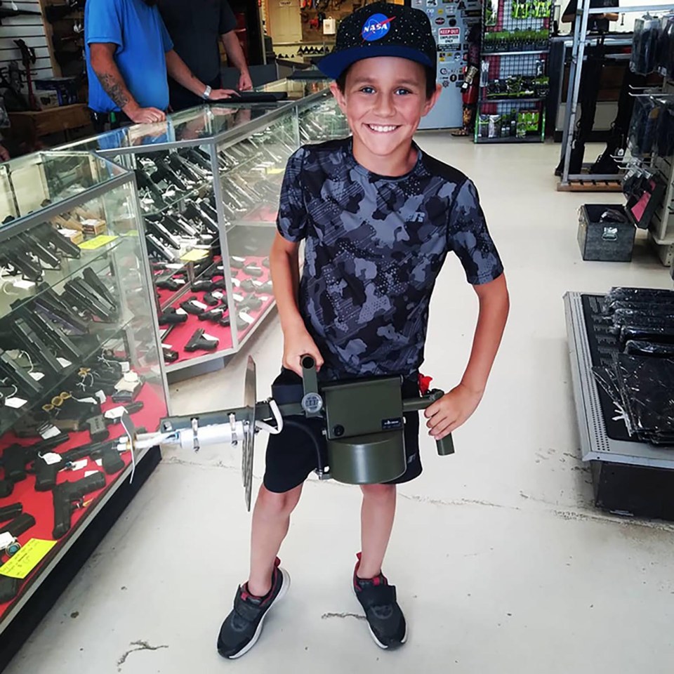 Boy holding a gun in a store.