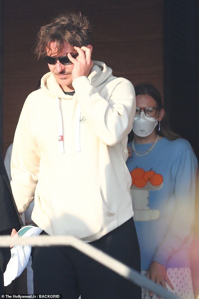 Cooper donned a white hoodie and black shorts for the sunset outing. He sported a mustache, but was otherwise clean shaven, and wore shades as well
