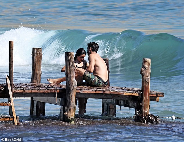 The performer's love interest was in dark green-and-black camouflage swim shorts