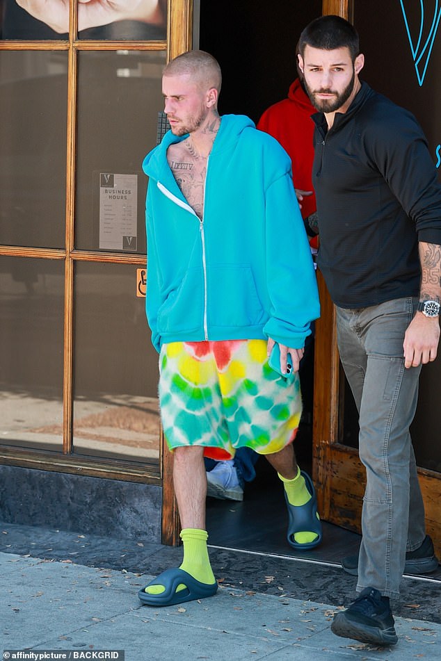 With a halfway unzipped blue hoodie exposing his bare chest, the Baby hitmaker put on a disheveled appearance as he left Voda Spa