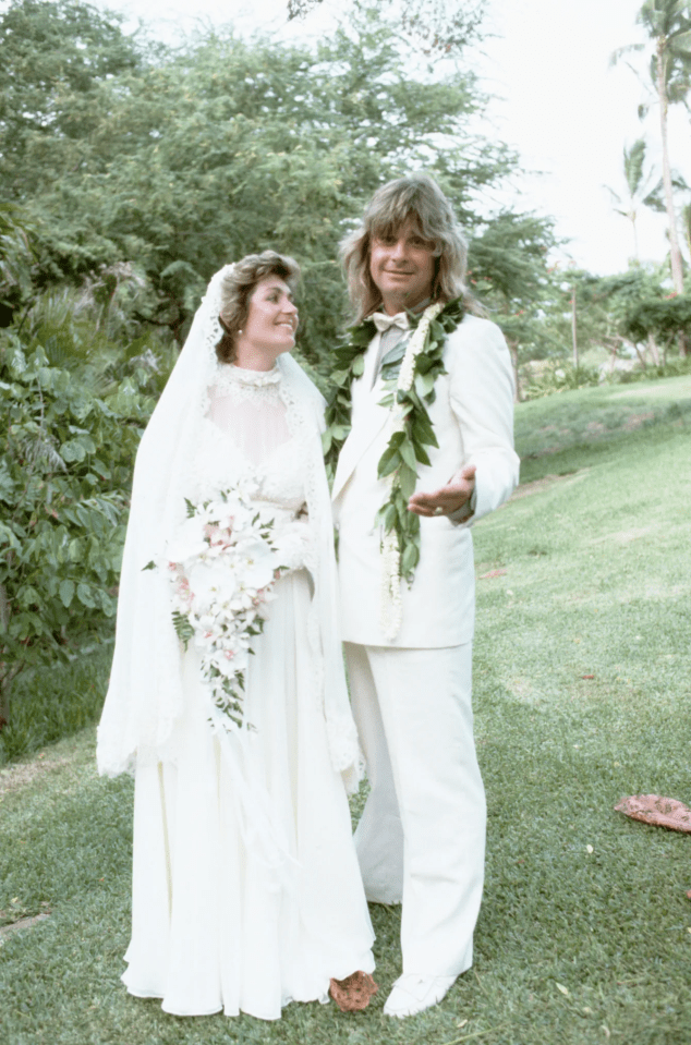 A bride and groom in white wedding attire on their wedding day.