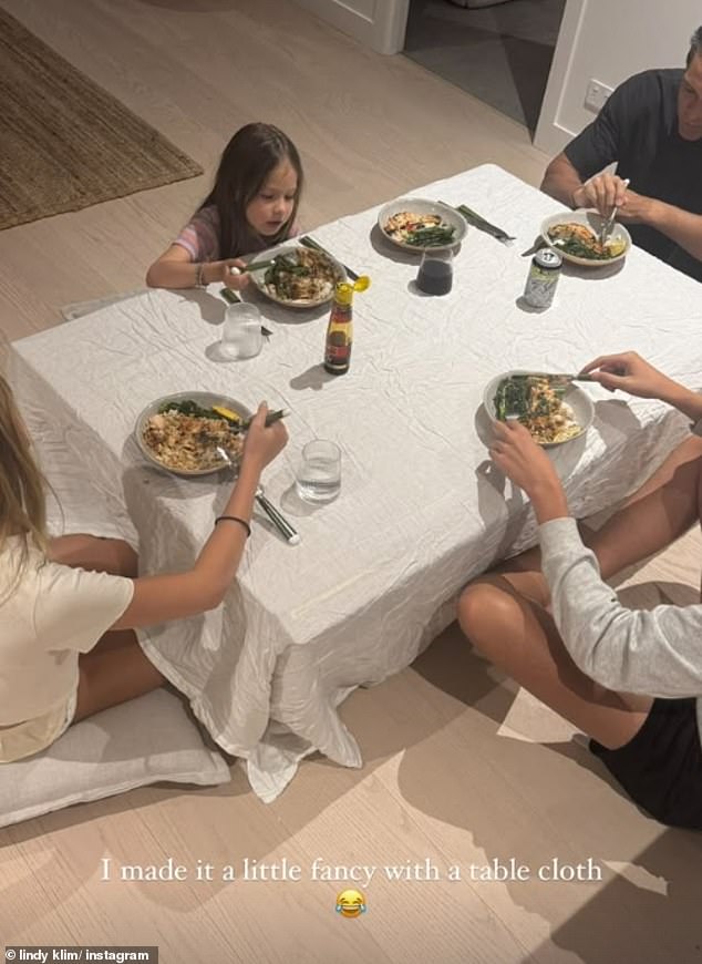 Lindy shared a second photo that showed evidence of her low-key dining set-up. The image showed what appeared to be Lindy's new beau, Paul Mullert, sitting cross legged on the floor with Lindy's youngest daughter Goldie, seven, and two more people, partially shown