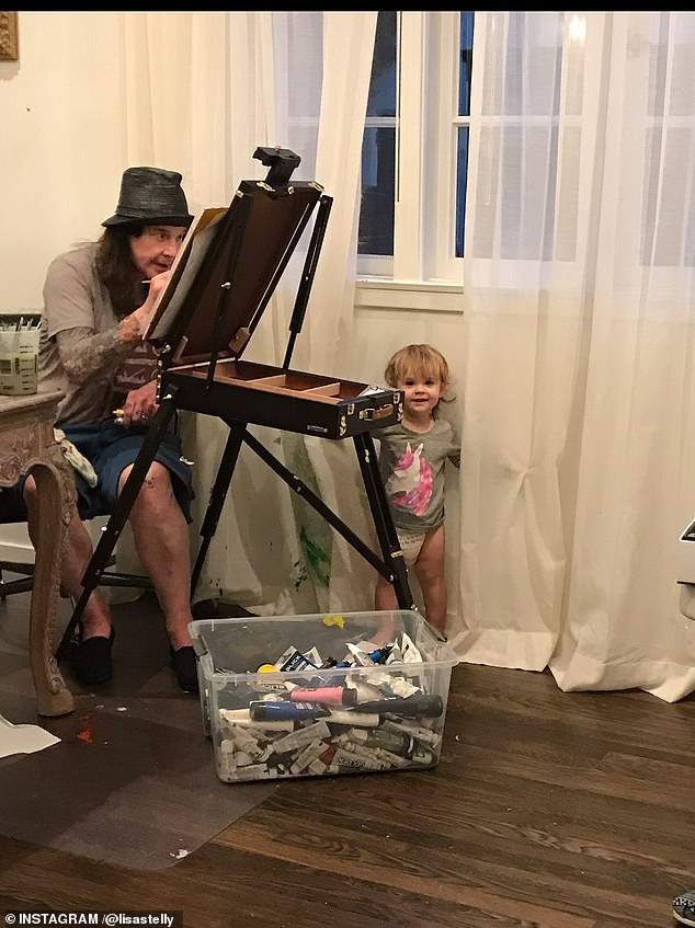 One of the little girls played with her grandfather as he tried to paint in another photo