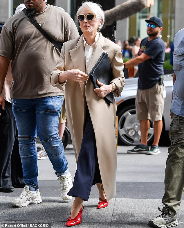 With a black leather folder tucked neatly under one of her arms, Meryl balanced expertly on a towering pair of scarlet stilettos that augmented her 5'6