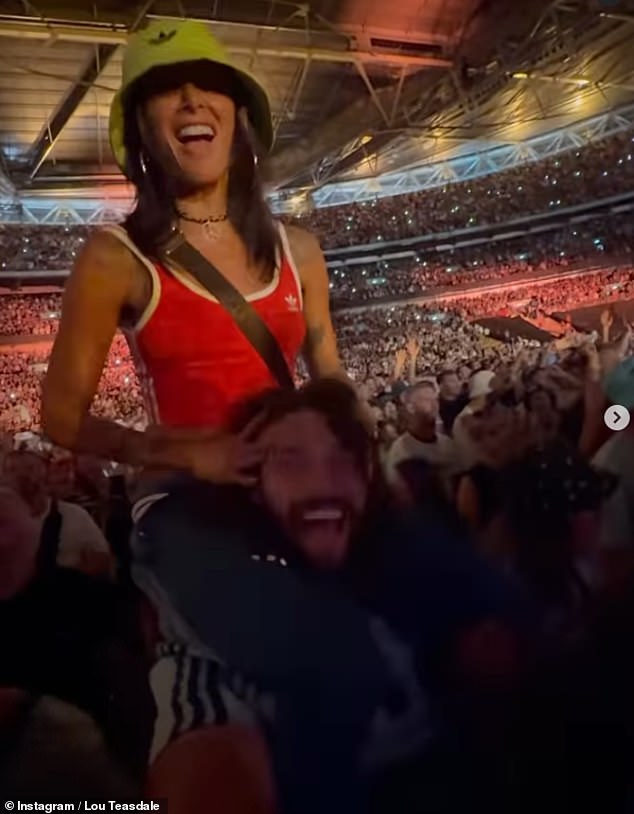 Lou slipped into a red Adidas crop top as she perched herself on Andy's shoulders to watch the live show