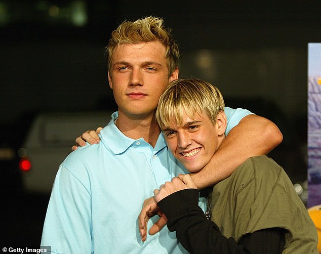 Aaron (right) with older brother Nick in 2004. The singer claimed his parents mishandled his money and neglected his finances