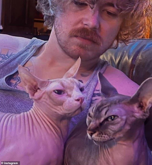 The music artist emotionally revealed to the audience during the set that he had to put his beloved hairless cat Creature down before the band's performance; Creature seen far left